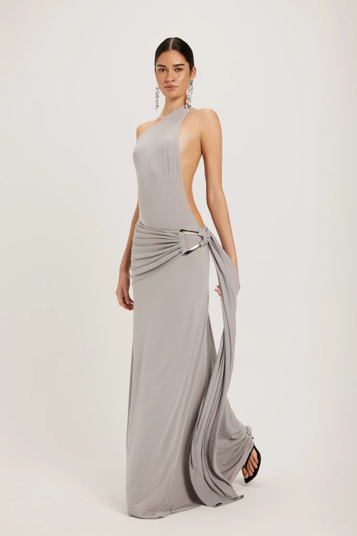 Ance Gria Gaia Gown Hire (Silver Grey). A stunning, backless, floor-length dress with silver-hardware waistband detailing.